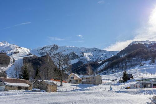 a village in the snow with mountains in the background at Riserva Bianca Limone Hotel & SPA in Limone Piemonte