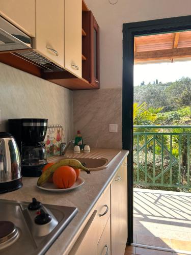 a kitchen with a counter with a plate of fruit on it at Corfù Appartamenti Dellis - Close to the beach in Káto Spílaion