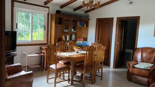 a dining room with a wooden table and chairs at La Fincurri del Nando in A Coruña