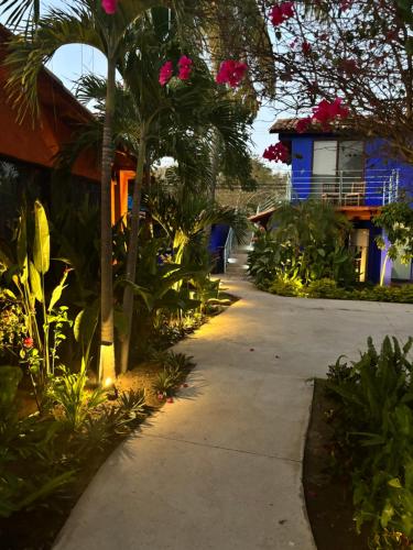 a sidewalk in front of a house with pink flowers at Casa Brisas in Troncones