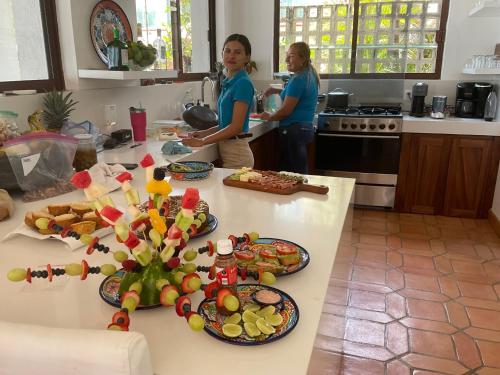 two women standing in a kitchen with plates of food at Casa Brisas in Troncones