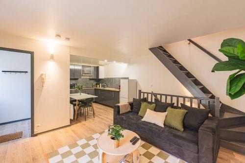 un salon avec un canapé et une cuisine dans l'établissement Le Pastel - 10 couchages - proche Cathédrale, à Reims