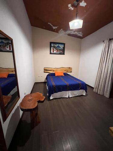a bedroom with a bed and a table in it at NEIZAN HOTEL in Antigua Guatemala