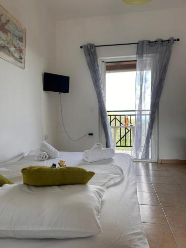 a bedroom with two white beds with a window at Corfù Appartamenti Dellis - Close to the beach in Káto Spílaion