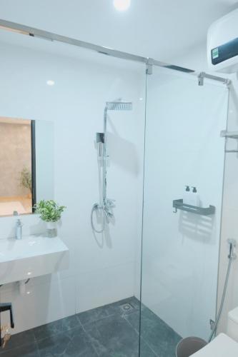 a bathroom with a glass shower and a sink at Sam Sam Studio - 2 Dragons WestLake - Washing machine in Hanoi