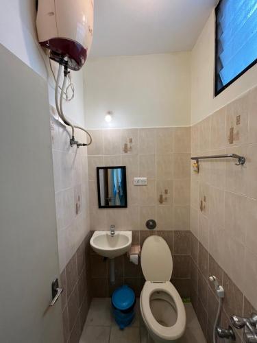 un baño con inodoro y lavabo en Paris Apartment, en Pondicherry