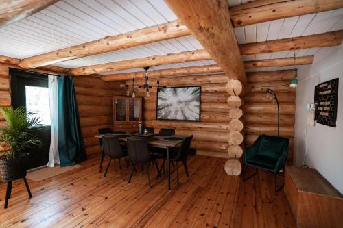 a dining room with a table and black chairs at Cozy Log Cabin with Spa - 3 min of Tremblant in Lac-Superieur