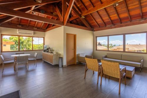 salon ze stołem, krzesłami i oknami w obiekcie Apto 102 T10 Eco Resort com 2 qts w mieście Tamandaré