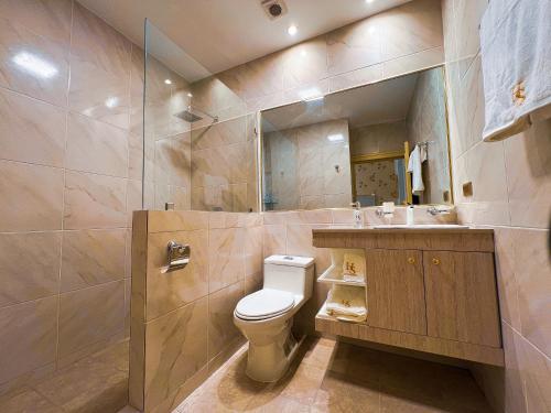 a bathroom with a toilet and a sink and a mirror at Hotel Sucre in Quito