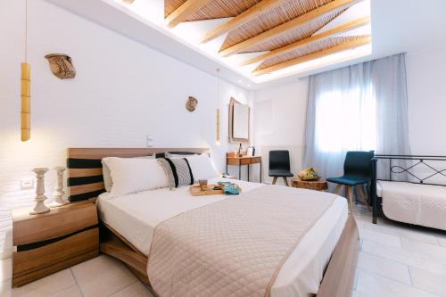a bedroom with a large bed and a room with a bed at Studios Kahlua in Agios Prokopios