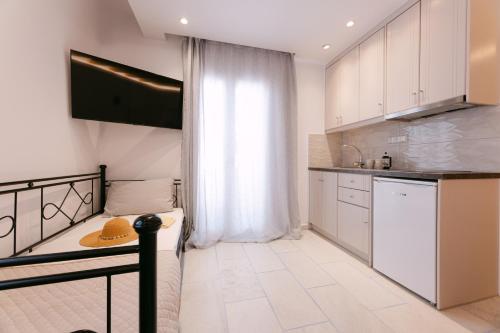 a kitchen with white cabinets and a table with a hat on it at Studios Kahlua in Agios Prokopios
