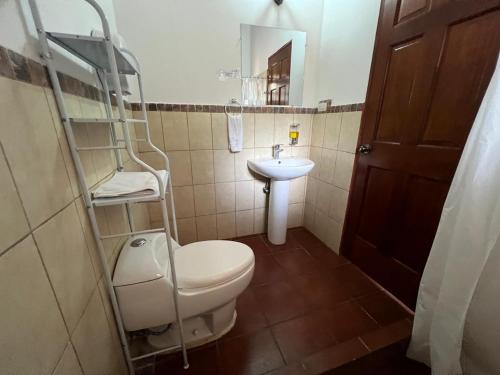 a small bathroom with a toilet and a sink at NEIZAN HOTEL in Antigua Guatemala