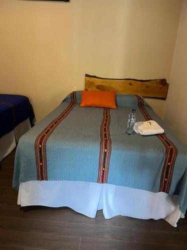 a bedroom with a bed with a phone on it at NEIZAN HOTEL in Antigua Guatemala