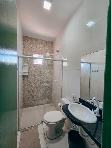 a bathroom with a toilet and a sink and a shower at Pousada Rio do Prado in Porto Seguro