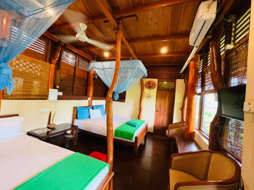 a bedroom with two beds and a tv in it at The Green View Yala in Tissamaharama