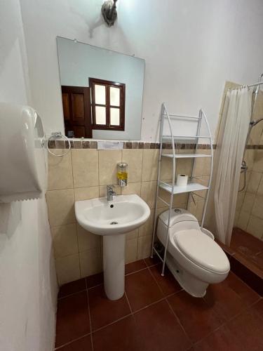 a bathroom with a sink and a toilet and a mirror at NEIZAN HOTEL in Antigua Guatemala