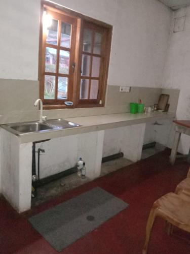 a kitchen with a sink and a window at Rimadi Lake Guest Inn in Eravur