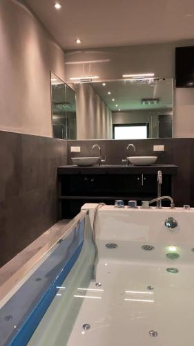 a bathroom with a bath tub and a sink at Villa Münchweiler in Münchweiler Rodalb