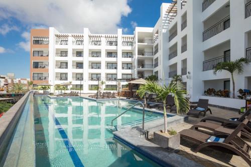 a swimming pool in front of a building at Medano Hotel and Spa in Cabo San Lucas