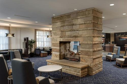 a stone fireplace in a lobby with chairs and tables at Courtyard by Marriott Gatlinburg Downtown in Gatlinburg