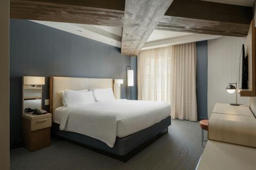 a bedroom with a large bed and a blue wall at Courtyard by Marriott Gatlinburg Downtown in Gatlinburg