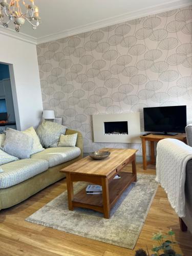 a living room with a couch and a coffee table at Wynnstay Apartment, Harbour and Mountain Views in Barmouth