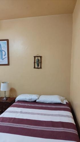 a bedroom with a bed with a striped blanket at Posada Los Chaneques Catemaco in Catemaco