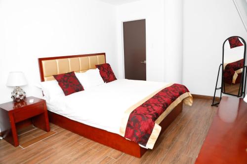 a bedroom with a bed and a table with a lamp at Kings Pavilion Suites Hotel in Basse Terre Town