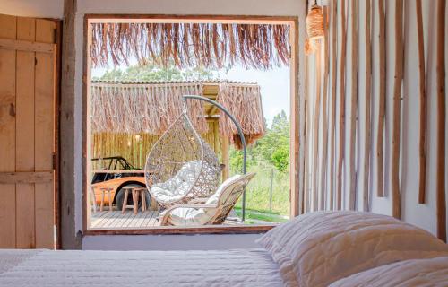 a bedroom with a porch with a swing and a chair at Cabana Serena in Corumbau