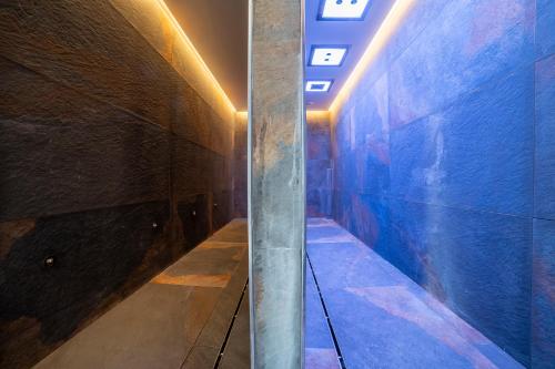 a hallway with a blue wall and a ceiling at Riserva Bianca Limone Hotel & SPA in Limone Piemonte