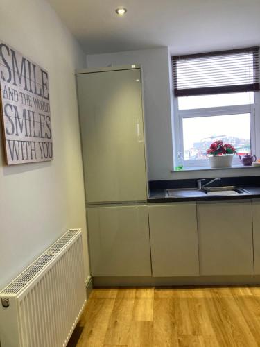 a kitchen with a refrigerator and a window in it at Wynnstay Apartment, Harbour and Mountain Views in Barmouth