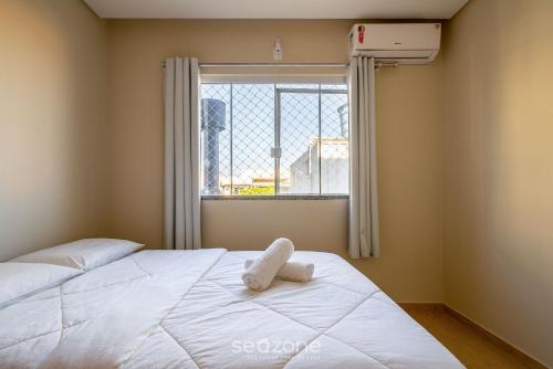 ein Schlafzimmer mit einem weißen Bett mit einem Fenster in der Unterkunft Casa 2Q c/ churrasq. 600m da praia RVL1183 in Canto Grande