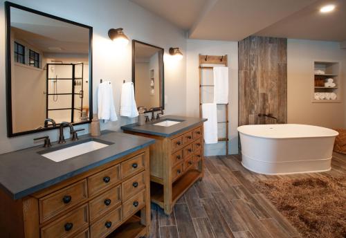 a bathroom with two sinks and a bath tub at The Njörd in Duluth