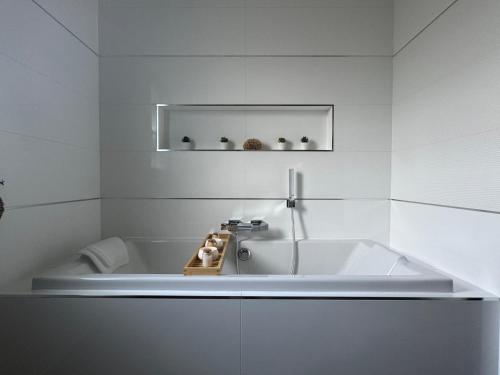 une salle de bain blanche avec une baignoire et un lavabo dans l'établissement Appartement vue mer, à Plougastel-Daoulas