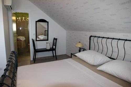 a bedroom with a bed and a chair and a mirror at Mountain Stone Villa with pool in Stanići