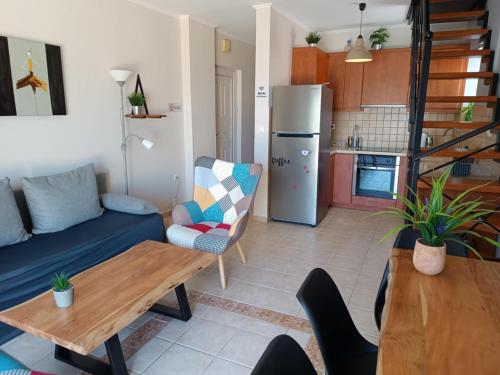 a living room with a blue couch and a kitchen at Hermione Horizon in Ermioni