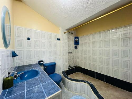 a bathroom with a blue sink and a tub at Departamento Familiar en el Centro de Baños in Baños