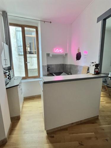 - une cuisine avec un comptoir avec un signe d'amour sur le mur dans l'établissement Des appartements au calme dans un immeuble historique, à Béziers