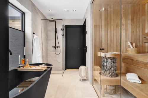 a bathroom with a shower and a sink and a mirror at Arctic aurora lodge with jacuzzi and sauna in Lyngværet