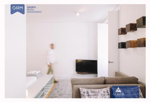 a living room with a couch and a tv at ORM - Almada Apartments in Porto