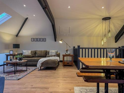 a living room with a couch and a table at Converted Welsh Sunday School with Sea View & Garden on Anglesey - Dog Friendly in Amlwch