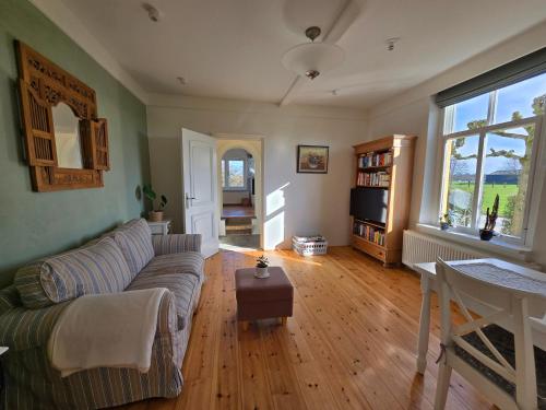 a living room with a couch and a tv at Sfeervol landelijk boerderijappartement Het Voorhuis in Horssen