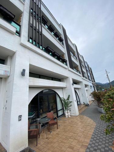 a building with a patio with a table and chairs at 大溪漁港蜜月灣Luna民宿2號館 in Toucheng