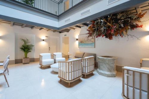 a waiting room with white chairs and a waiting area with aoodoo at La Caleta QE Hotels in Cádiz