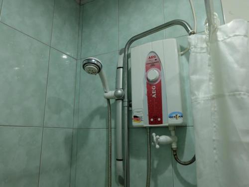 eine Dusche mit rotem Gegenstand im Bad in der Unterkunft A&A Plaza Hotel in Puerto Princesa