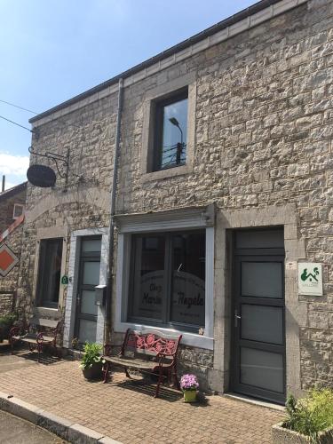a brick building with a bench in front of a window at Chez Marie-Angèle in Treignes