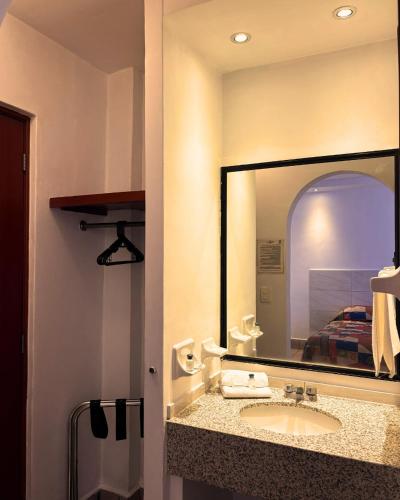 a bathroom with a sink and a large mirror at Hotel Arboledas Industrial in Guadalajara