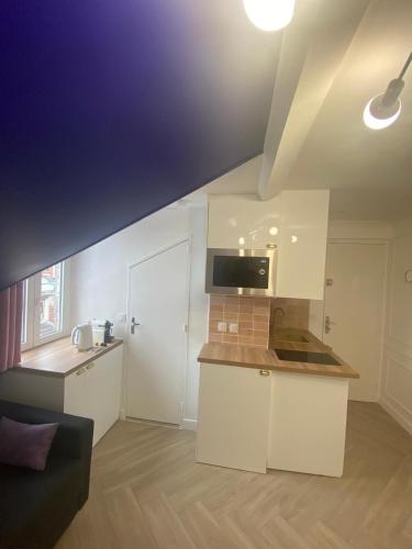 une cuisine avec des armoires blanches et un comptoir dans l'établissement Parisian style 10 min from Paris, à Aubervilliers