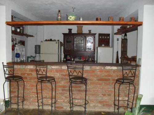 a brick bar with four bar stools in a kitchen at Posada la Arcadia in Pedro Gonzalez