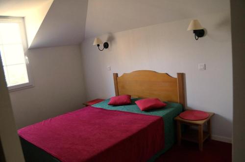 - une chambre dotée d'un lit avec des draps rouges et verts dans l'établissement La résidence du Lac - maeva Home - Appartement 2 pièces 5 personnes - Sélection MAE-2491, à Monflanquin